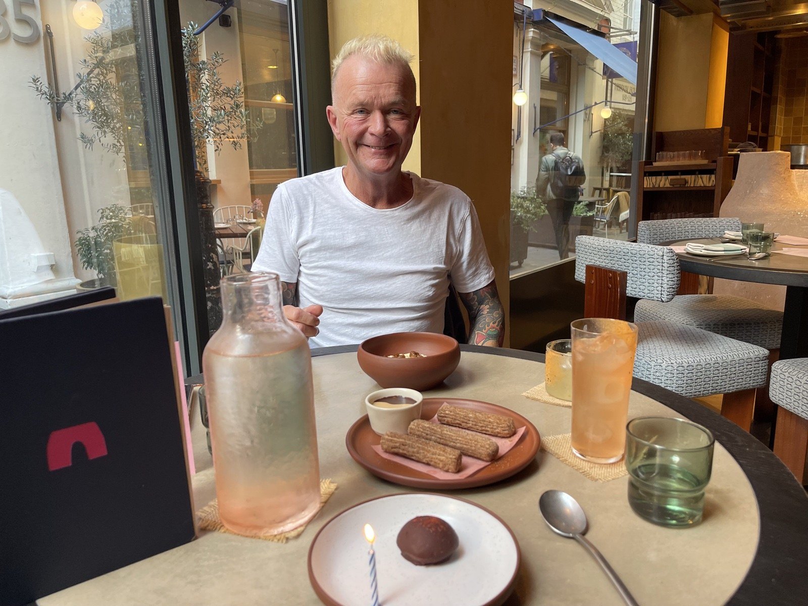 Birthday smile across the table at Fonda with churros and a lit candle